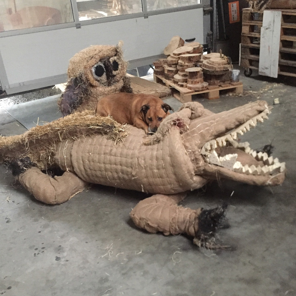 Hier sehen Sie ein Krokodil aus Stroh, auf dem ein Hund schläft